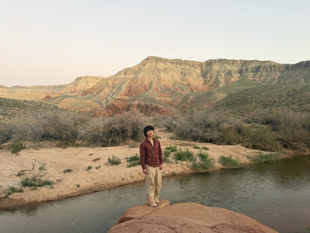 Winston standing on a rock next to the river at sunset in Utah