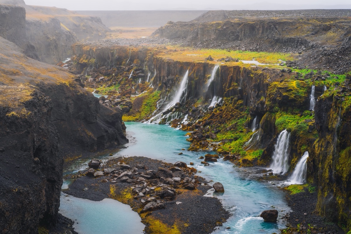 Dozens of waterfalls spilling into the turquoise river at Sigoldugljufur canyon, Iceland