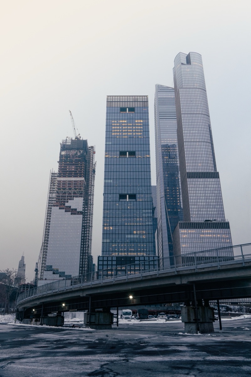 Hudson Yards towers rising into winter fog above a snow-covered overpass, New York